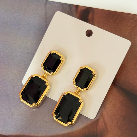 Arete dorado con piedra negra