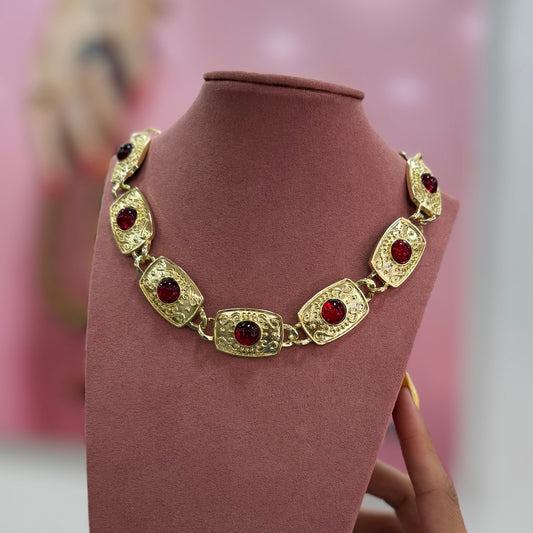 Collar dorado con piedra roja